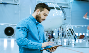 Man with tablet in airplane hangar