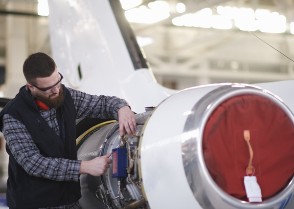 Mitarbeiter, der an einer Flugzeugturbine arbeitet 